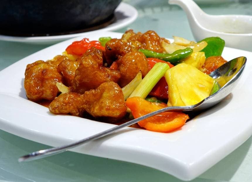 Plato de chancho en salsa agridulce con piña y verduras.